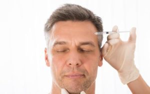 Vain Man getting Botox injection in forehead